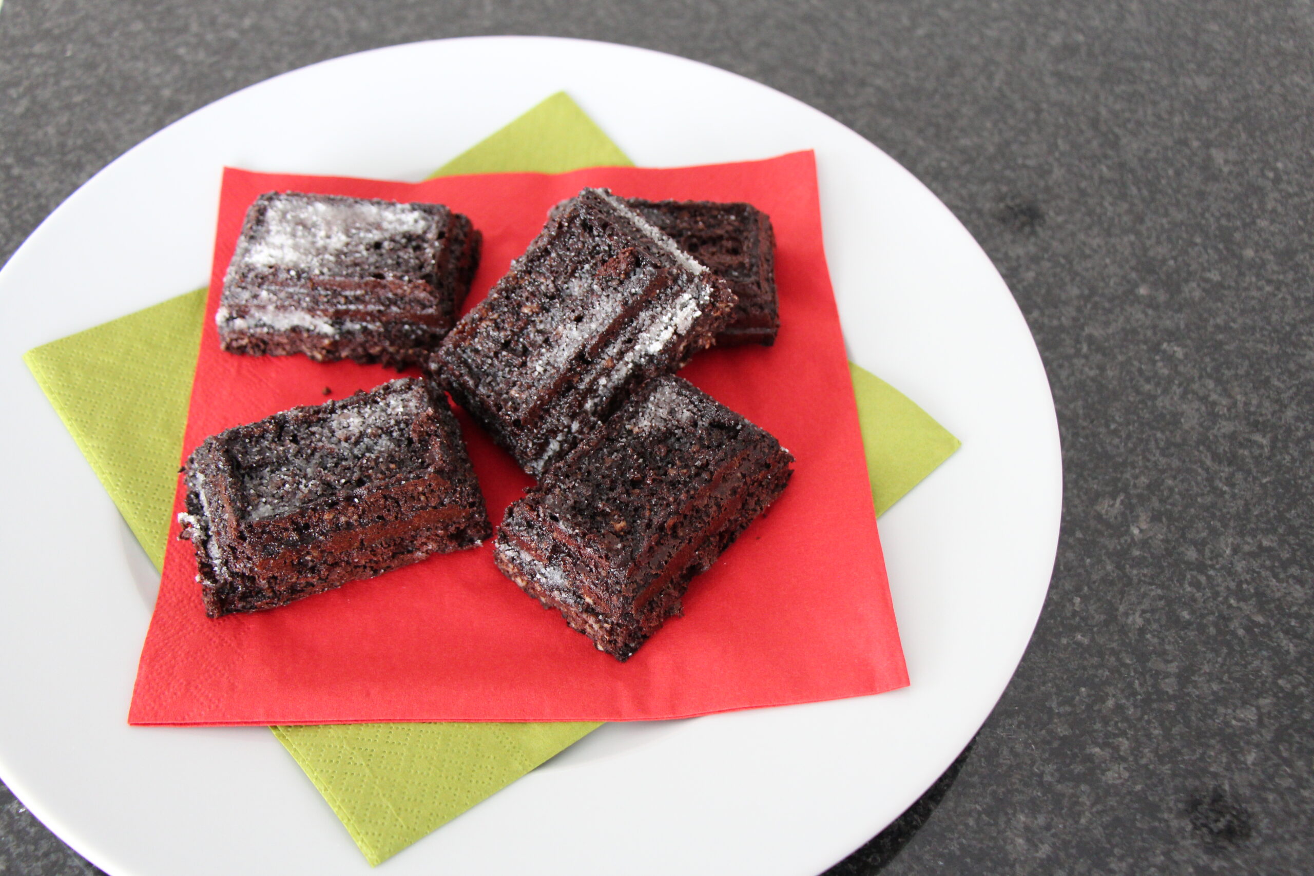 Haferflocken-Brownies mit Joghurt und etwas Puderzucker auf einem Teller